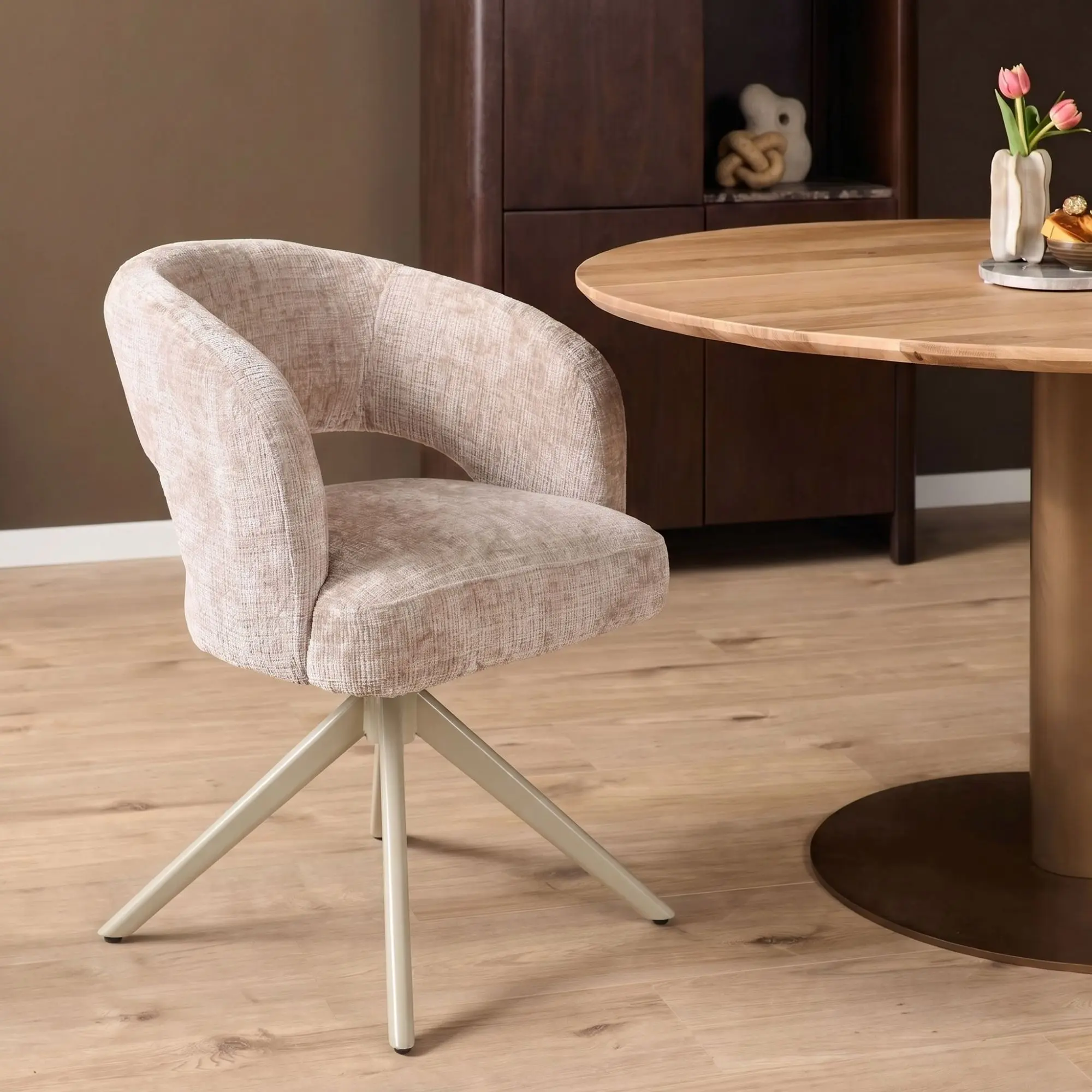 Draaibare armstoel Demi in beige stof met zand metalen onderstel aan ronde eettafel
