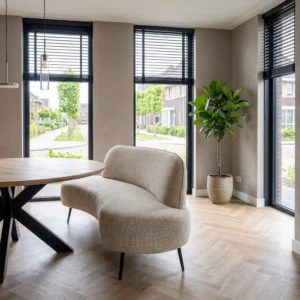 Eetkamerbank met organische vorm in beige stof aan een ronde eettafel in een modern interieur