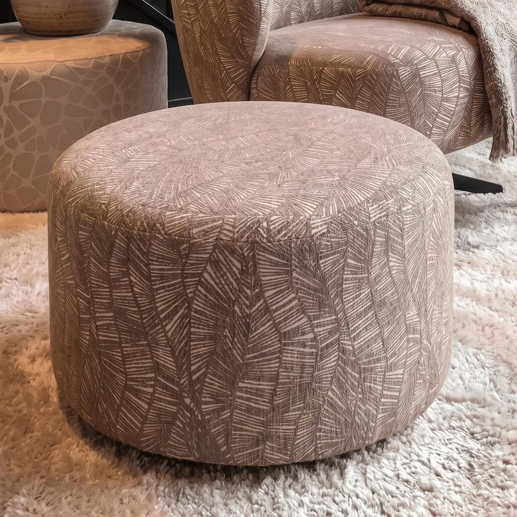 Ronde poef 50cm cylinder in taupe patroonstof op een hoogpolig vloerkleed