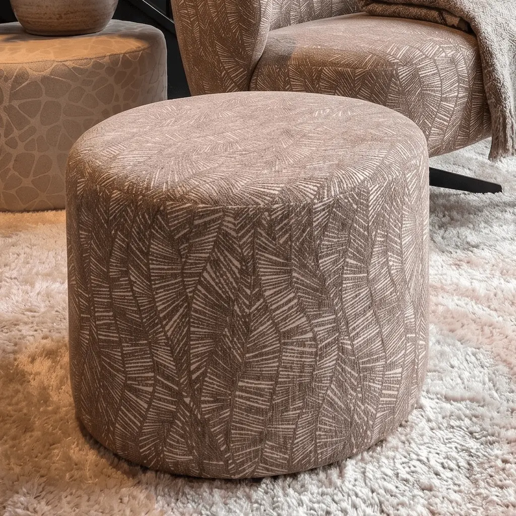 Ronde poef 50cm cylinder in taupe patroonstof op een hoogpolig vloerkleed